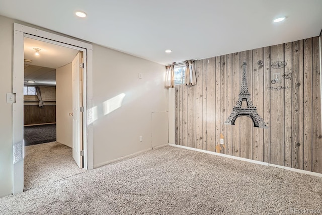 basement with recessed lighting, wood walls, and carpet floors