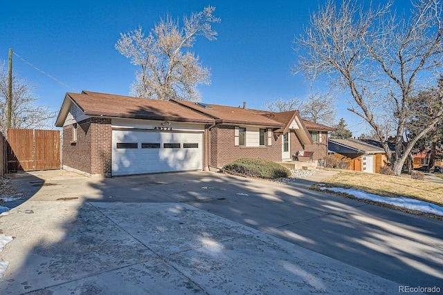 ranch-style house with brick siding, concrete driveway, a garage, and fence