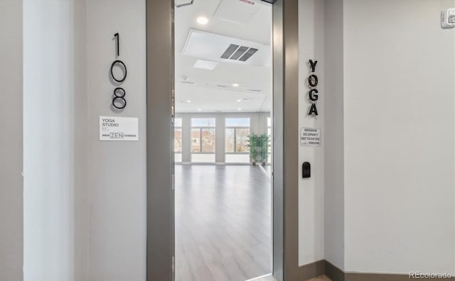 corridor featuring a wall of windows and light wood-type flooring