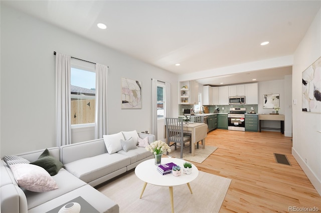 living room with light wood-type flooring and a healthy amount of sunlight