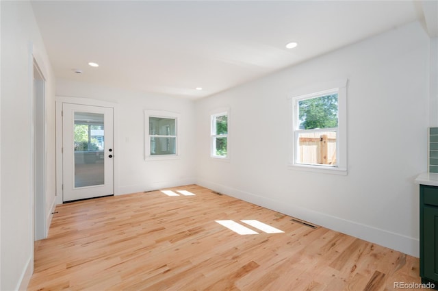 spare room with a healthy amount of sunlight and light wood-type flooring