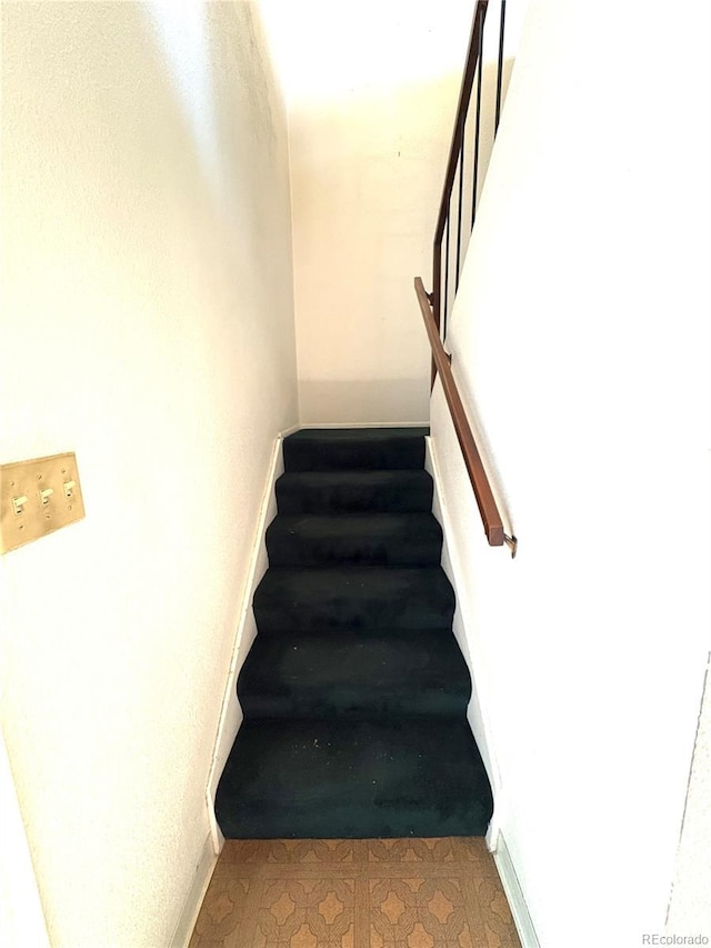 staircase featuring baseboards