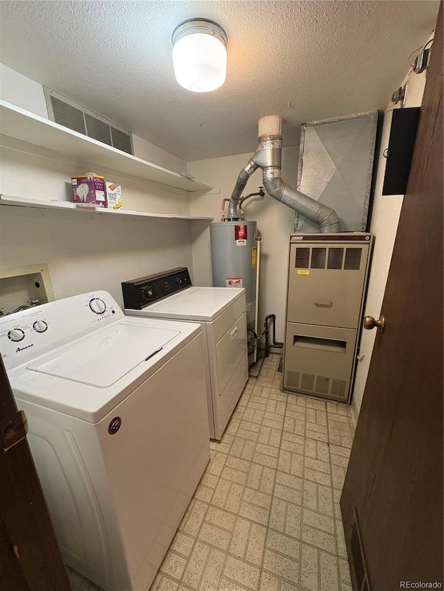 washroom with visible vents, laundry area, a textured ceiling, gas water heater, and independent washer and dryer