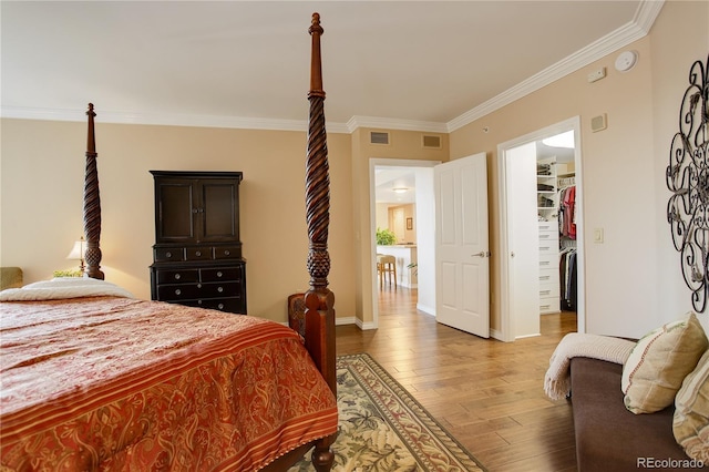 8100 E Union Ave Unit 1502, Denver, CO 80237 - bedroom with light wood finished floors, ornamental molding, a walk in closet, and baseboards