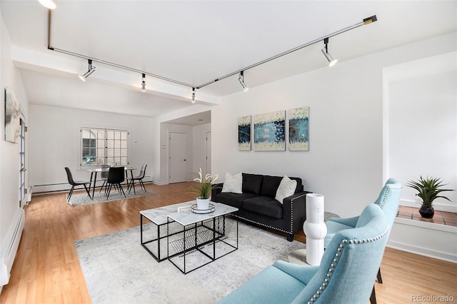 living room featuring a baseboard radiator, track lighting, and wood finished floors