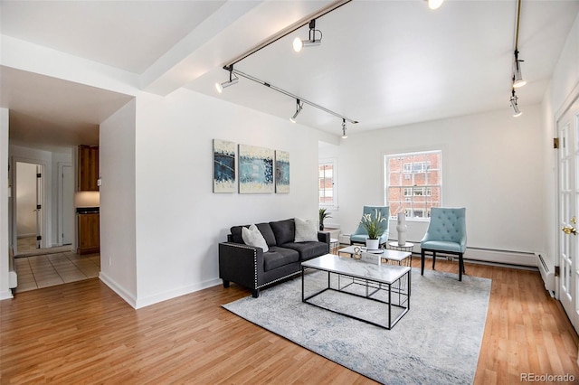 living room with track lighting, baseboards, and light wood finished floors