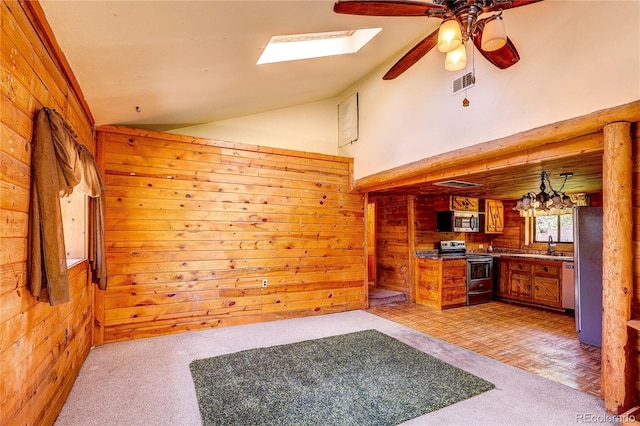 10893 Milliken Ave, Conifer, CO 80433 - unfurnished living room with a ceiling fan, vaulted ceiling, a skylight, and wooden walls