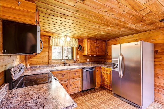 10893 Milliken Ave, Conifer, CO 80433 - kitchen featuring appliances with stainless steel finishes, wood ceiling, wooden walls, and brown cabinets