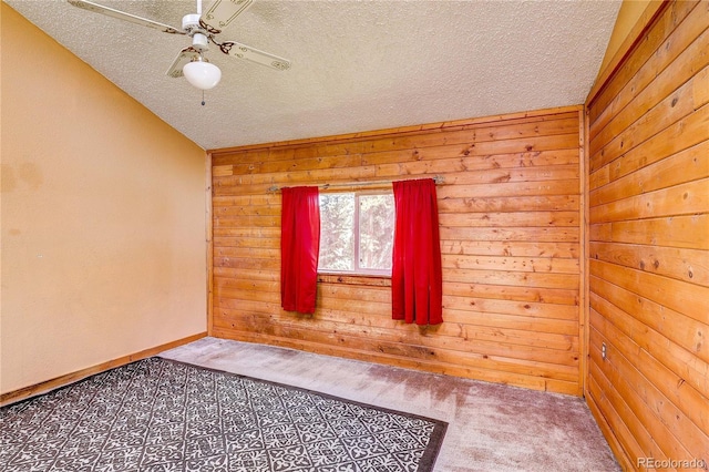 10893 Milliken Ave, Conifer, CO 80433 - carpeted empty room featuring wooden walls, a textured ceiling, and ceiling fan