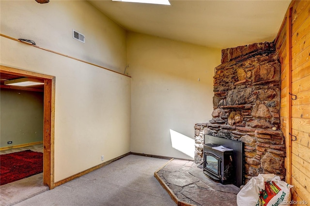 10893 Milliken Ave, Conifer, CO 80433 - unfurnished living room featuring a wood stove and carpet floors