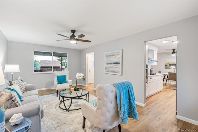 living room featuring light hardwood / wood-style flooring and ceiling fan