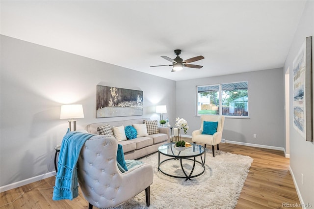 living room with ceiling fan and light hardwood / wood-style flooring