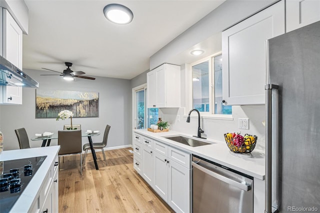 kitchen featuring white cabinets, stainless steel appliances, light hardwood / wood-style floors, sink, and ceiling fan