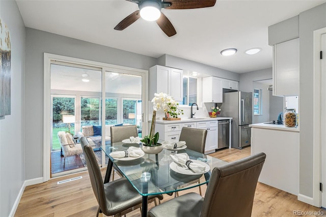 dining space featuring ceiling fan, light hardwood / wood-style floors, and sink