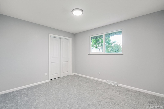 unfurnished bedroom featuring carpet and a closet