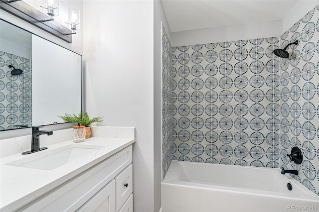 bathroom with tiled shower / bath combo and vanity