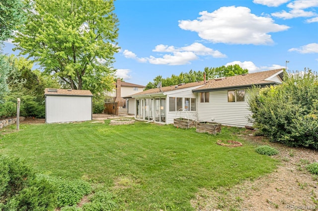 back of house featuring a storage unit and a yard