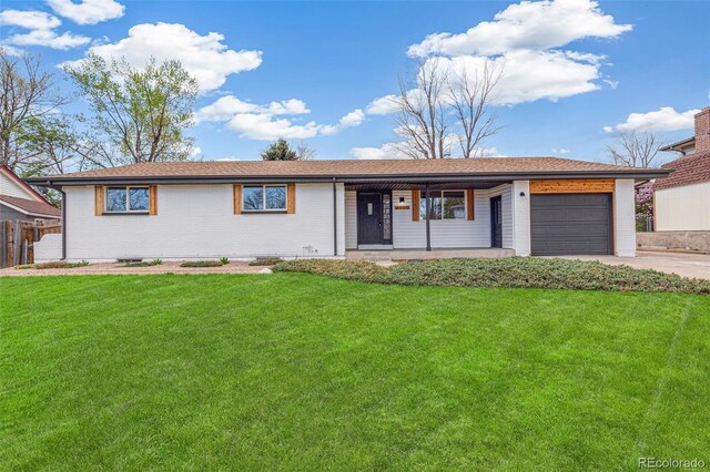 single story home with a garage, covered porch, a front yard, brick siding, and driveway