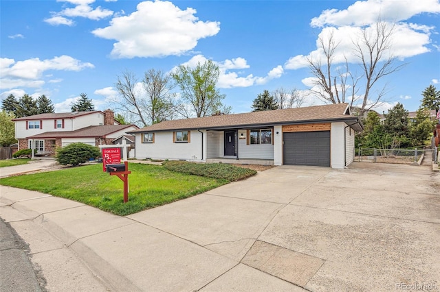 view of front of home featuring fence, an attached garage, driveway, and a front lawn