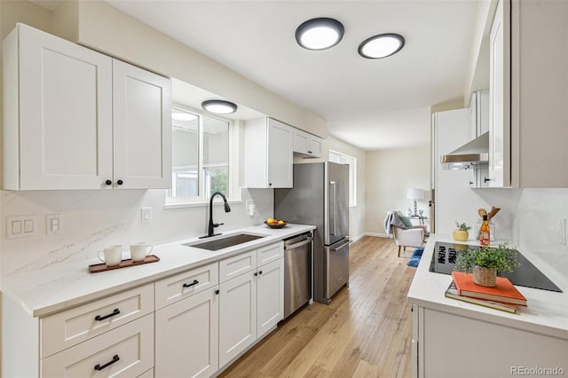 kitchen featuring light wood-type flooring, a sink, white cabinetry, and stainless steel appliances