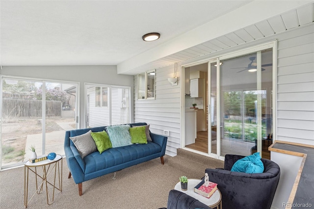 living room with carpet floors, ceiling fan, and lofted ceiling