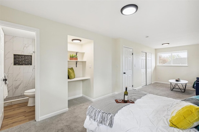 carpeted bedroom featuring baseboards and connected bathroom