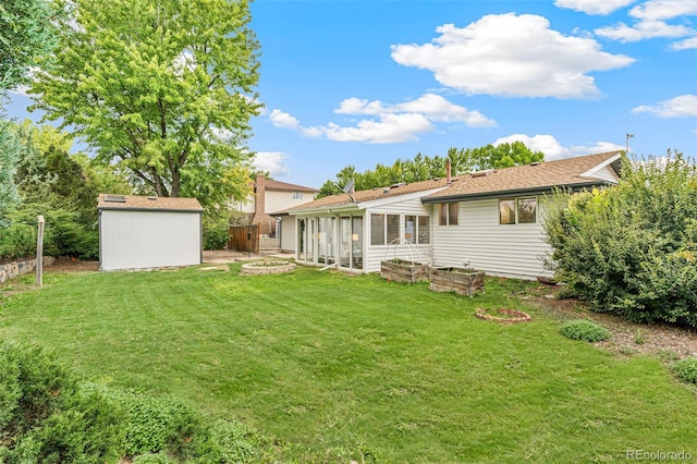 back of house with a yard, an outbuilding, a sunroom, and a shed