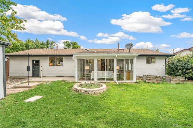 rear view of property featuring a sunroom, a yard, and a patio area