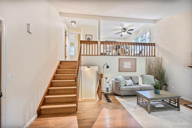 5602 S Yank Ct, Littleton, CO 80127 - living room with wood finished floors, ceiling fan, stairway, and beam ceiling