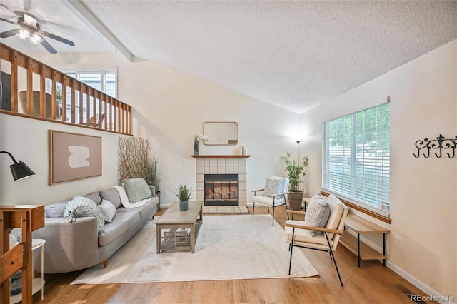 5602 S Yank Ct, Littleton, CO 80127 - living area with a textured ceiling, a fireplace, plenty of natural light, a ceiling fan, and wood finished floors