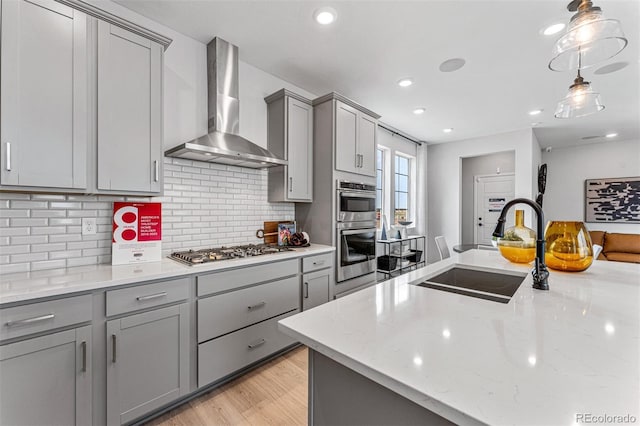2110 Wagon Wheel Aly, Brighton, CO 80601 - kitchen with wall chimney range hood, gray cabinetry, stainless steel appliances, decorative backsplash, and recessed lighting