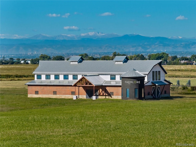 2110 Wagon Wheel Aly, Brighton, CO 80601 - back of house featuring a lawn, a mountain view, and a metal roof