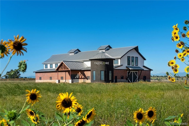 2110 Wagon Wheel Aly, Brighton, CO 80601 - rear view of property featuring a standing seam roof, brick siding, and a metal roof