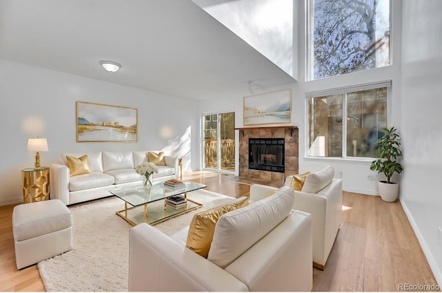 living room featuring a tiled fireplace and light hardwood / wood-style floors