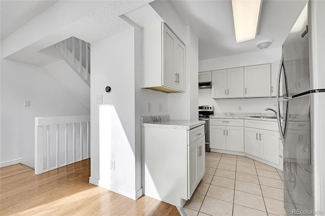 kitchen featuring white cabinetry, appliances with stainless steel finishes, sink, and light hardwood / wood-style flooring