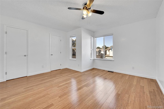 unfurnished bedroom with ceiling fan, light hardwood / wood-style floors, and a textured ceiling