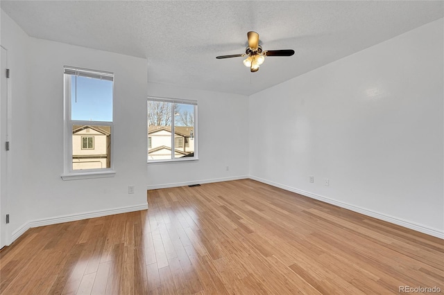 empty room with ceiling fan, a textured ceiling, and light hardwood / wood-style flooring