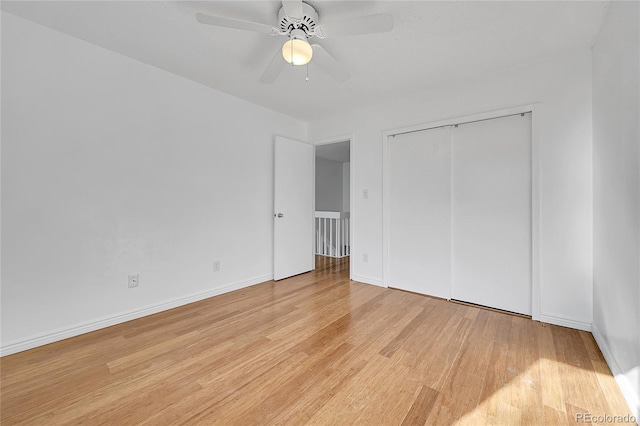 unfurnished bedroom featuring ceiling fan, a closet, and light hardwood / wood-style flooring