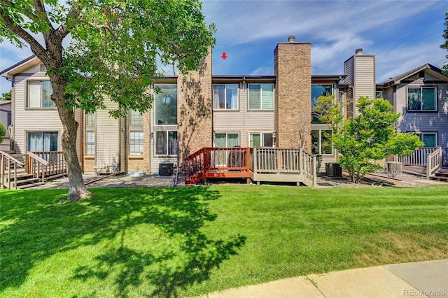 rear view of house featuring a wooden deck, central AC, and a lawn