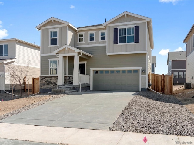 craftsman-style home featuring fence, an attached garage, concrete driveway, central air condition unit, and board and batten siding