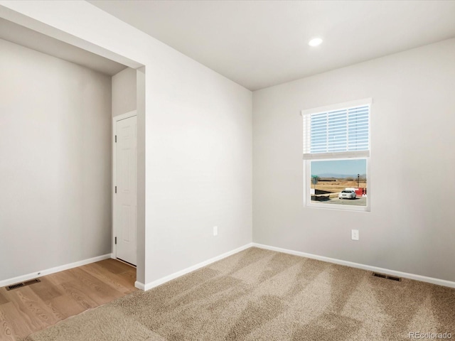 carpeted empty room featuring recessed lighting, visible vents, and baseboards