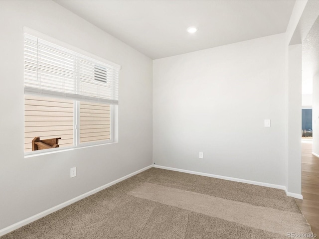 unfurnished room featuring carpet and baseboards