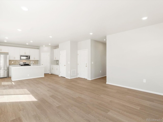 unfurnished living room featuring recessed lighting, baseboards, visible vents, and light wood finished floors