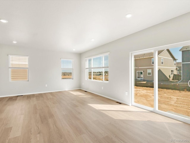 unfurnished room featuring recessed lighting, light wood-type flooring, and baseboards