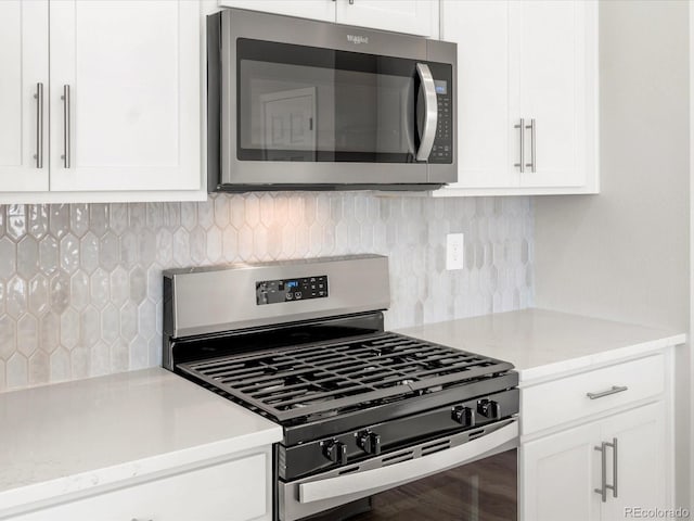 kitchen featuring white cabinetry, decorative backsplash, and stainless steel appliances