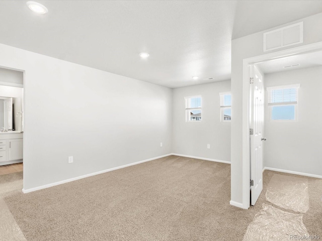 empty room with light carpet, visible vents, recessed lighting, and baseboards