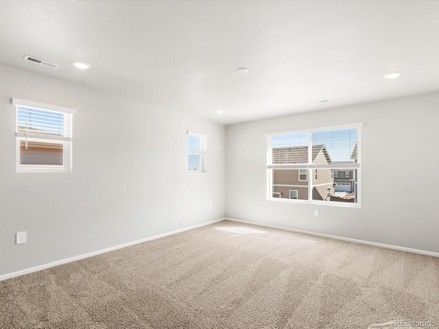 spare room featuring carpet flooring, baseboards, and visible vents