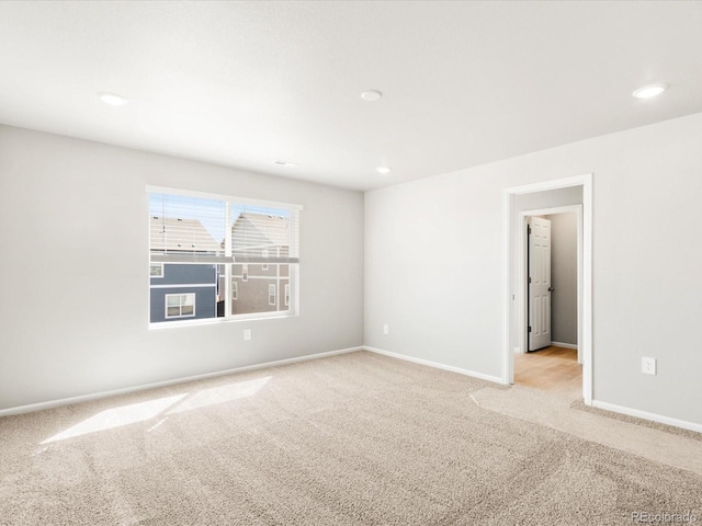 empty room with recessed lighting, baseboards, and light carpet