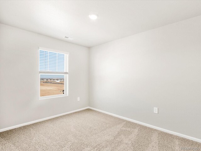 carpeted empty room with visible vents and baseboards