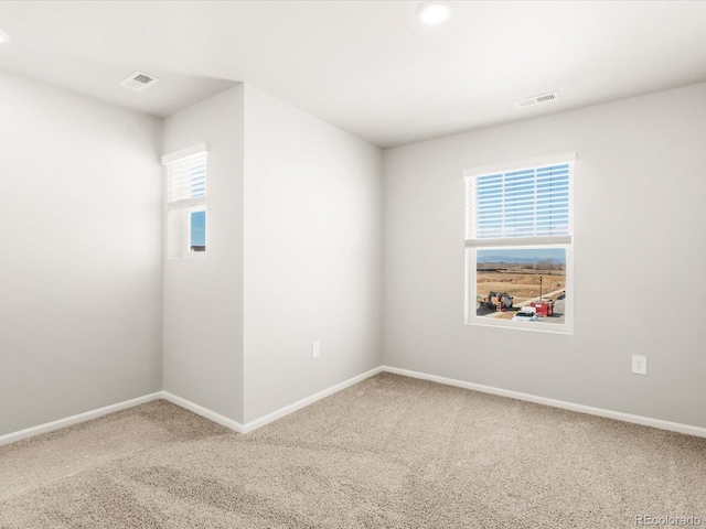 spare room featuring visible vents, baseboards, and carpet